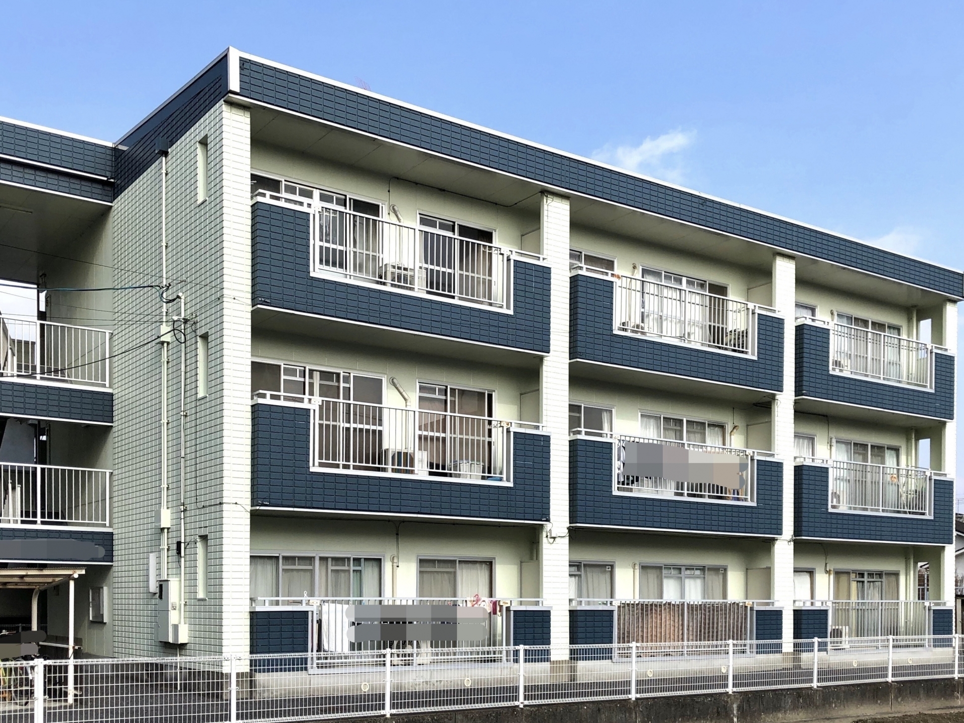 紺と白のツートンに塗り替えたアパート